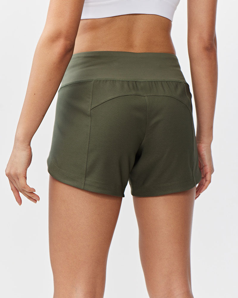 Person wearing olive green shorts on a white background